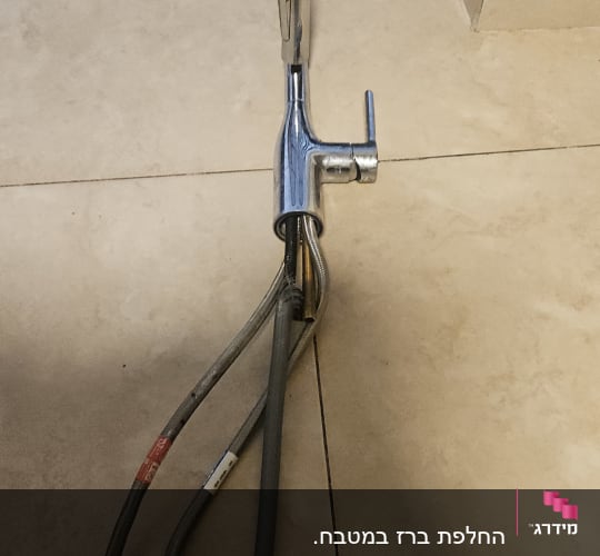 ברז וכבלים על רצפת אריחים